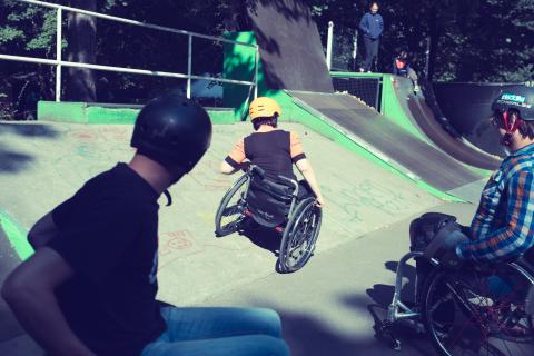 Rollstuhlfahrer:innen auf einer Skaterbahn