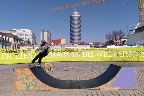Skater auf einer Halfpipe auf dem Theatervorplatz in Jena. Im Hintergrund sieht man einen Kran und den JenTower